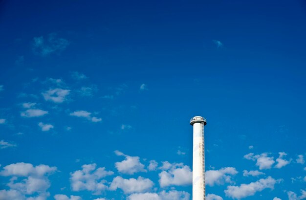 Low angle view of smoke stacks against blue sky