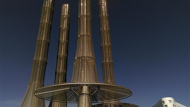 Low angle view of smoke stacks against clear sky