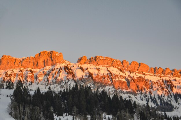 Low angle view of snow covered mountains against clear sky