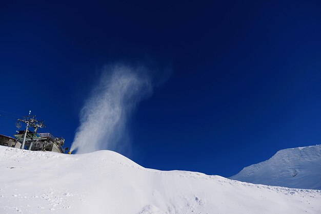 Low angle view of snowcapped mountain against blue sky