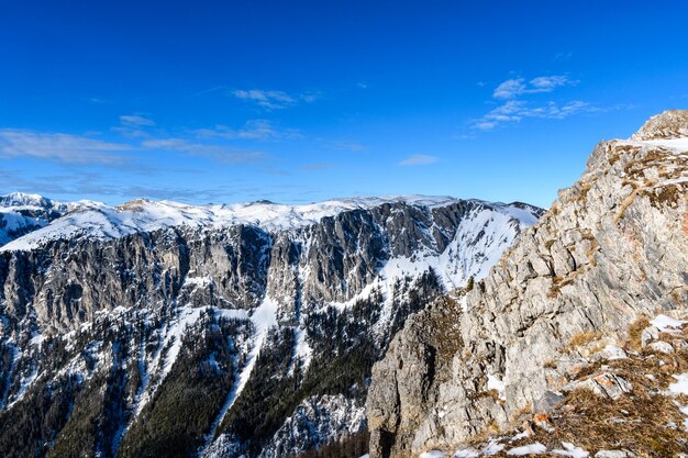 Low angle view of snowcapped mountain against blue sky