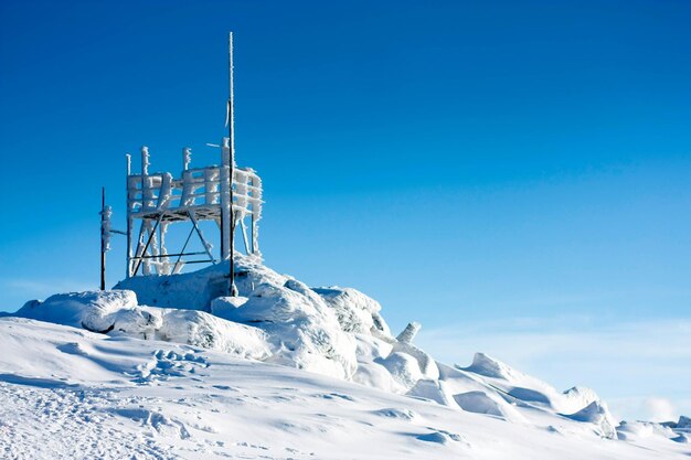 Low angle view of snowcapped mountain against clear blue sky