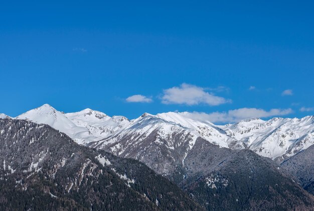 Low angle view of snowcapped mountains against blue sky