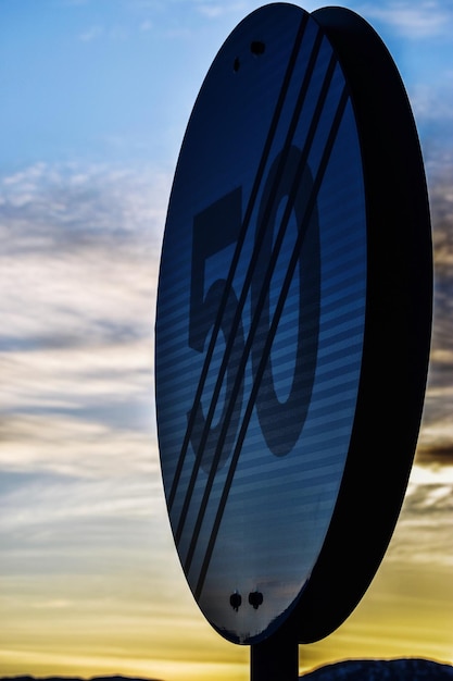 low angle view of speed limit sign against sky during sunset