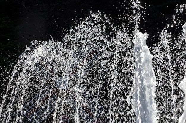 Foto vista a bassa angolazione dell'acqua della fontana che schizza contro il cielo di notte