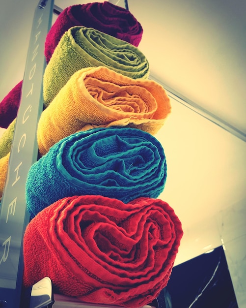 Foto vista ad angolo basso di asciugamani colorati impilati sullo scaffale in un negozio