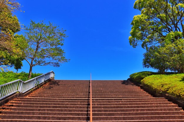 Low angle view of staircase by building against blue sky