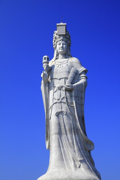 Low angle view of statue against blue sky