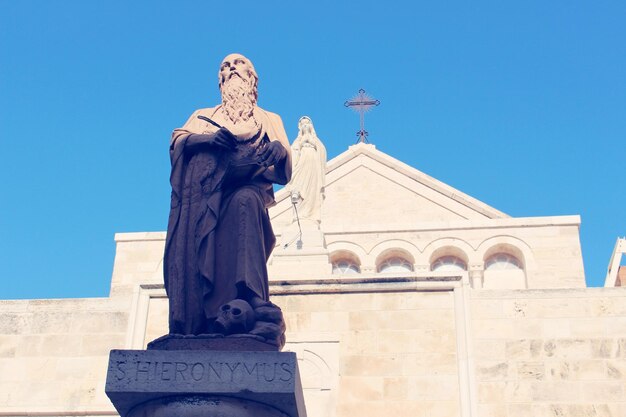 Low angle view of statue against blue sky