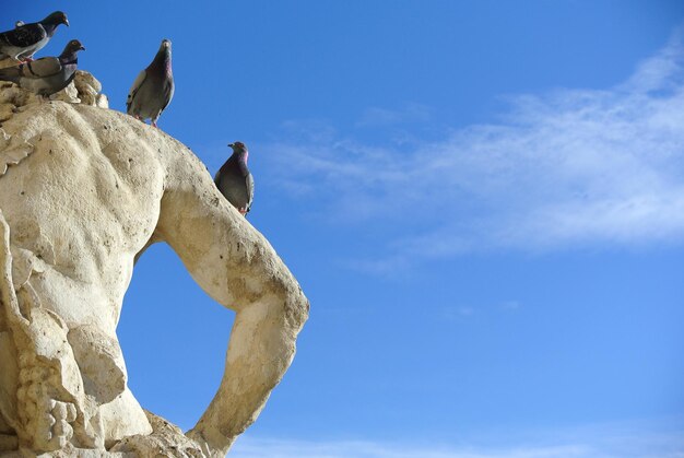 Low angle view of statue against blue sky