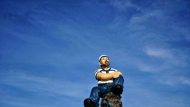 Low angle view of statue against blue sky