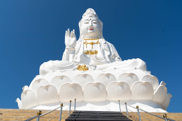 Low angle view of statue against building against clear blue sky
