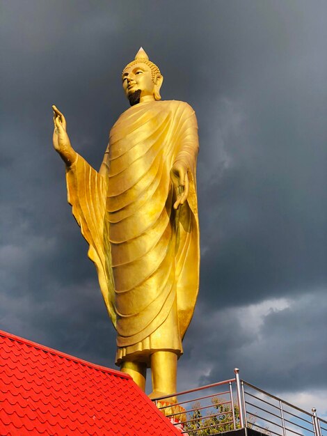 Low angle view of statue against building against sky