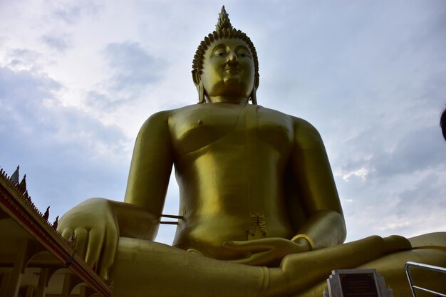 Photo low angle view of statue against temple building against sky