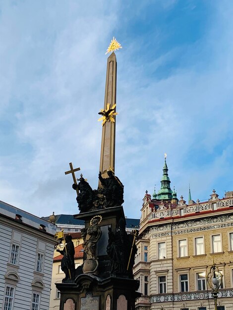 Low angle view of statue of building against cloudy sky