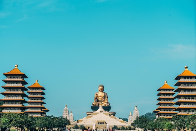 Low angle view of statue of buildings against blue sky