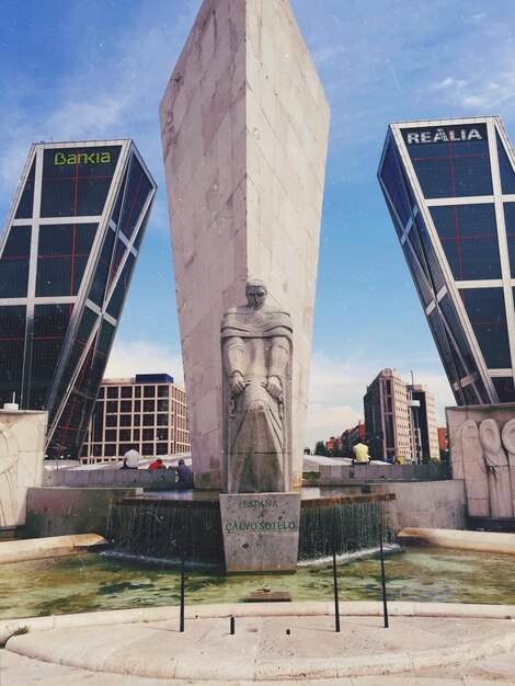 Foto vista a basso angolo della statua di fronte agli edifici