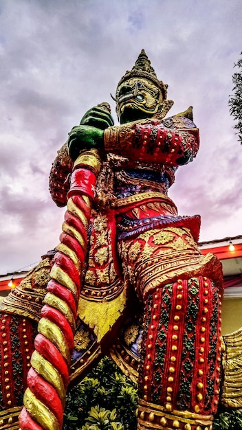 Low angle view of statue at temple against cloudy sky