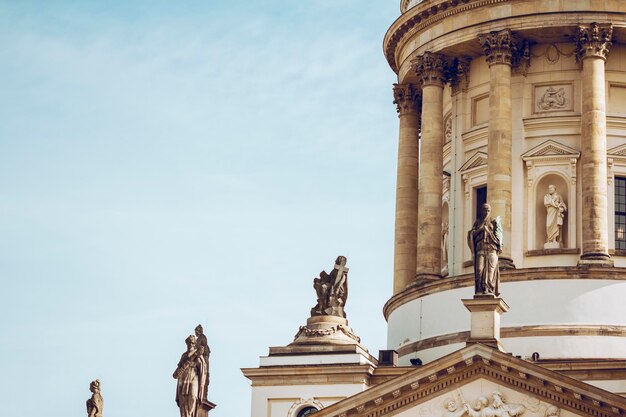 Photo low angle view of statues at neue kirche against sky in city