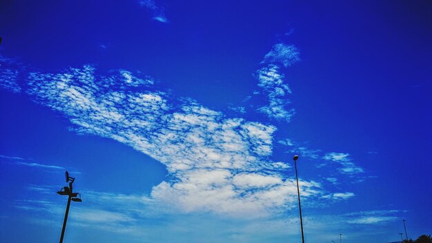 Low angle view of street light against blue sky