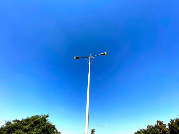 Low angle view of street light against blue sky