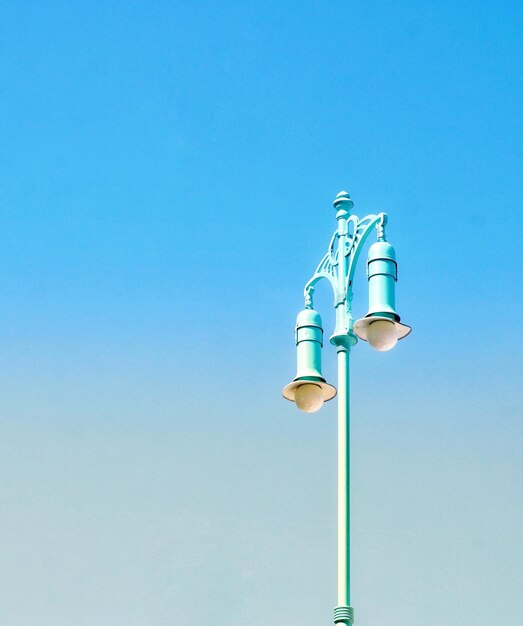 Low angle view of street light against blue sky