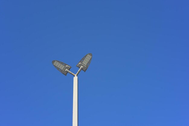 Low angle view of street light against blue sky