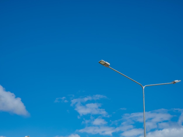 Low angle view of street light against blue sky