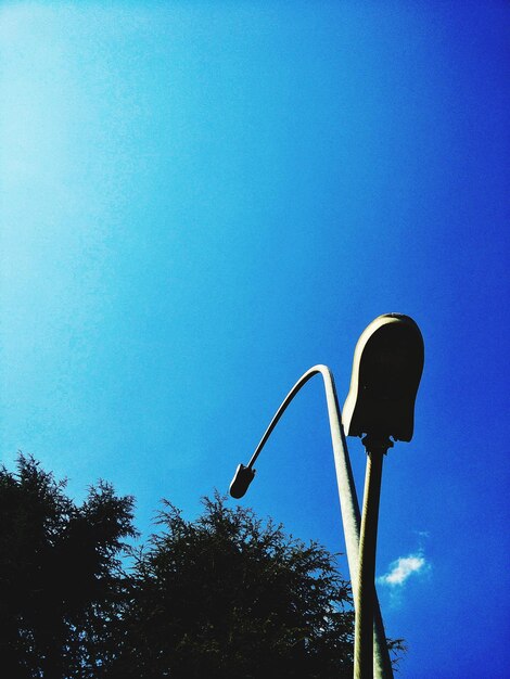 Low angle view of street light against blue sky