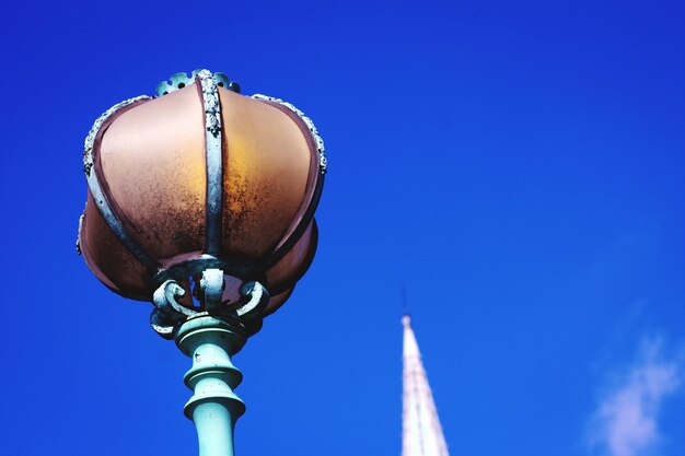 Low angle view of street light against blue sky