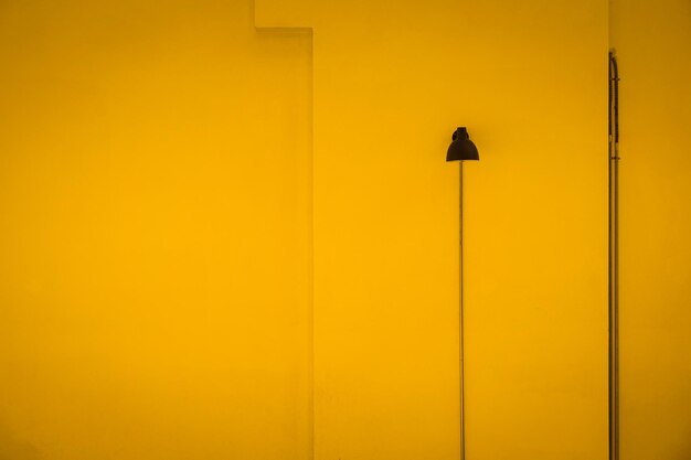 Low angle view of street light against orange wall