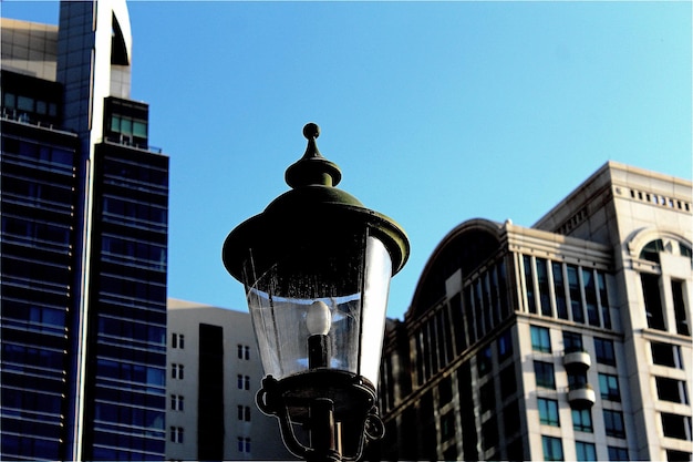 Photo low angle view of street light and buildings against clear blue sky