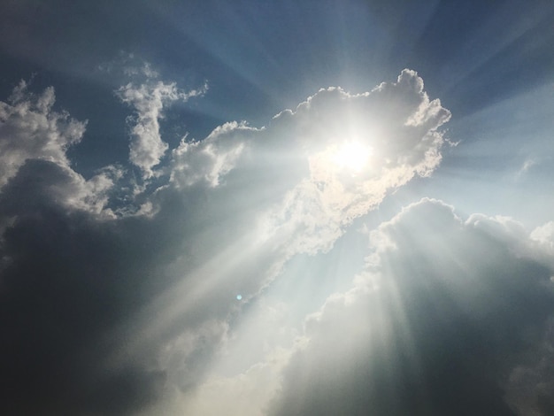 Photo low angle view of sunbeams streaming from clouds