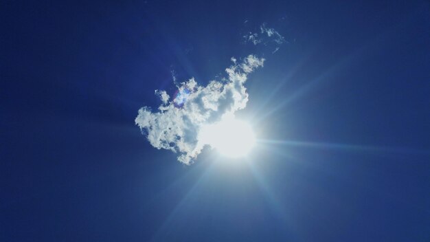 Low angle view of sunlight at blue sky