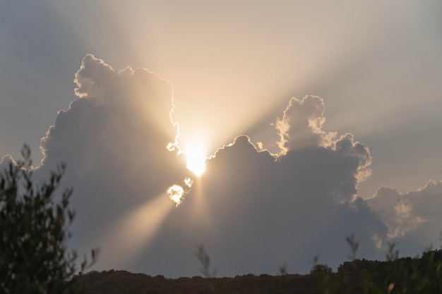 Foto vista a basso angolo della luce solare che scorre attraverso le nuvole durante il tramonto