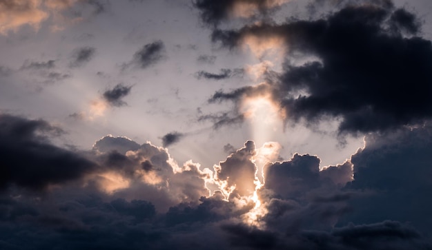 Foto vista a basso angolo della luce solare che scorre attraverso le nuvole durante il tramonto