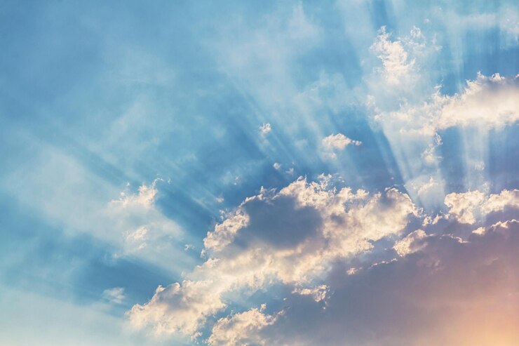 Photo low angle view of sunlight streaming through clouds