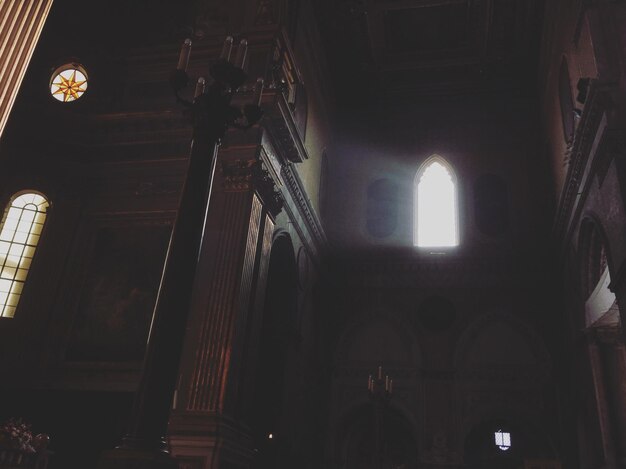 Low angle view of sunlight streaming through window in church