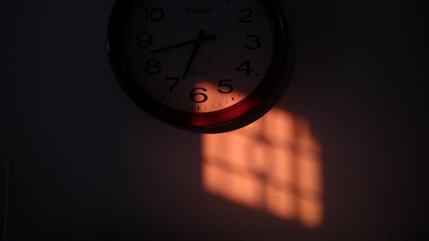 Photo low angle view of sunlight on wall clock at morning