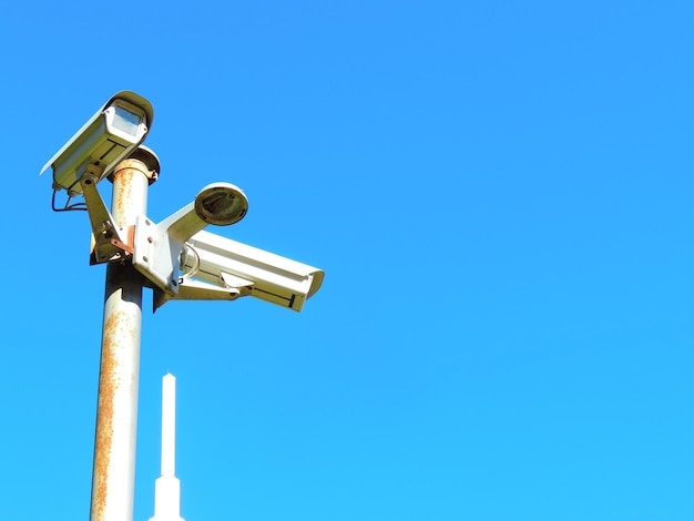 Low angle view of surveillance camera against sky