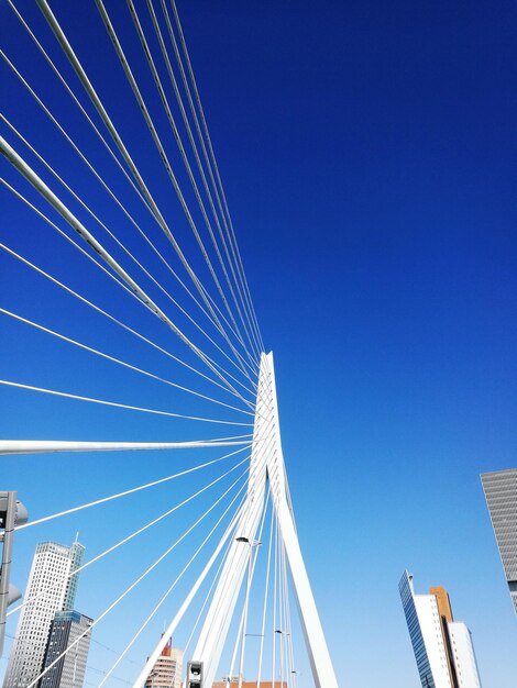 Low angle view of suspension bridge against blue sky