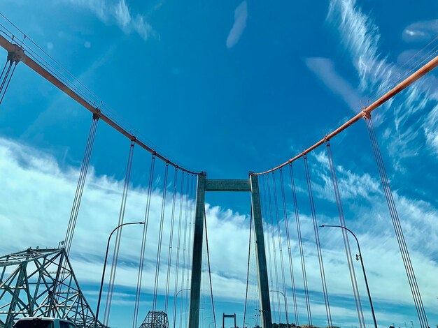 Low angle view of suspension bridge against sky