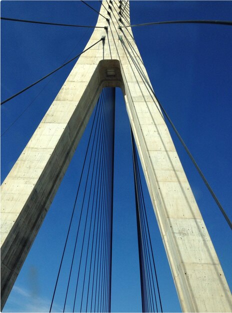 Low angle view of suspension bridge blue sky white structure