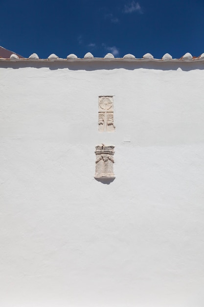 Low angle view of symbol carving on white church wall