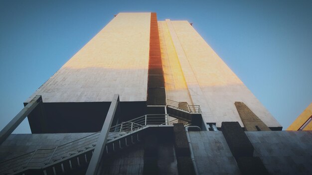 Low angle view of tall built structure against blue sky