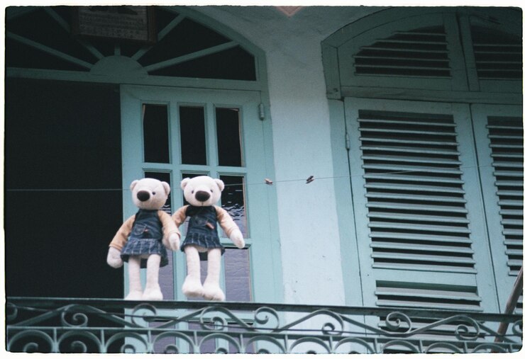 Photo low angle view of teddy bears hanging on rope against door