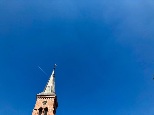 Low angle view of tower and building against blue sky