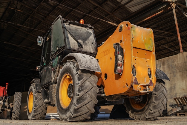 Photo low angle view of tractor in a barn. ordinary day on farm.