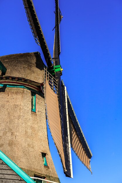 Foto vista a basso angolo di un mulino a vento tradizionale contro un cielo blu limpido