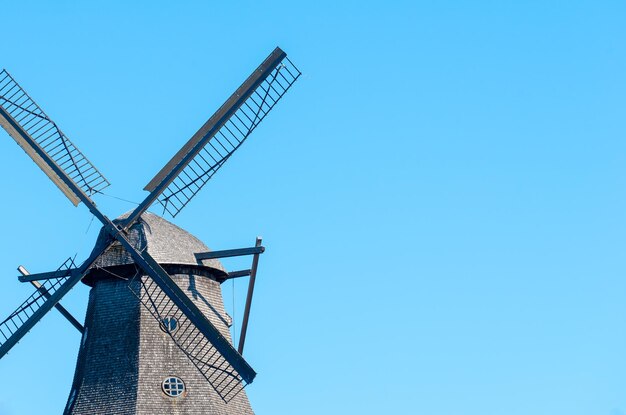 Low angle view of traditional windmill against clear blue sky